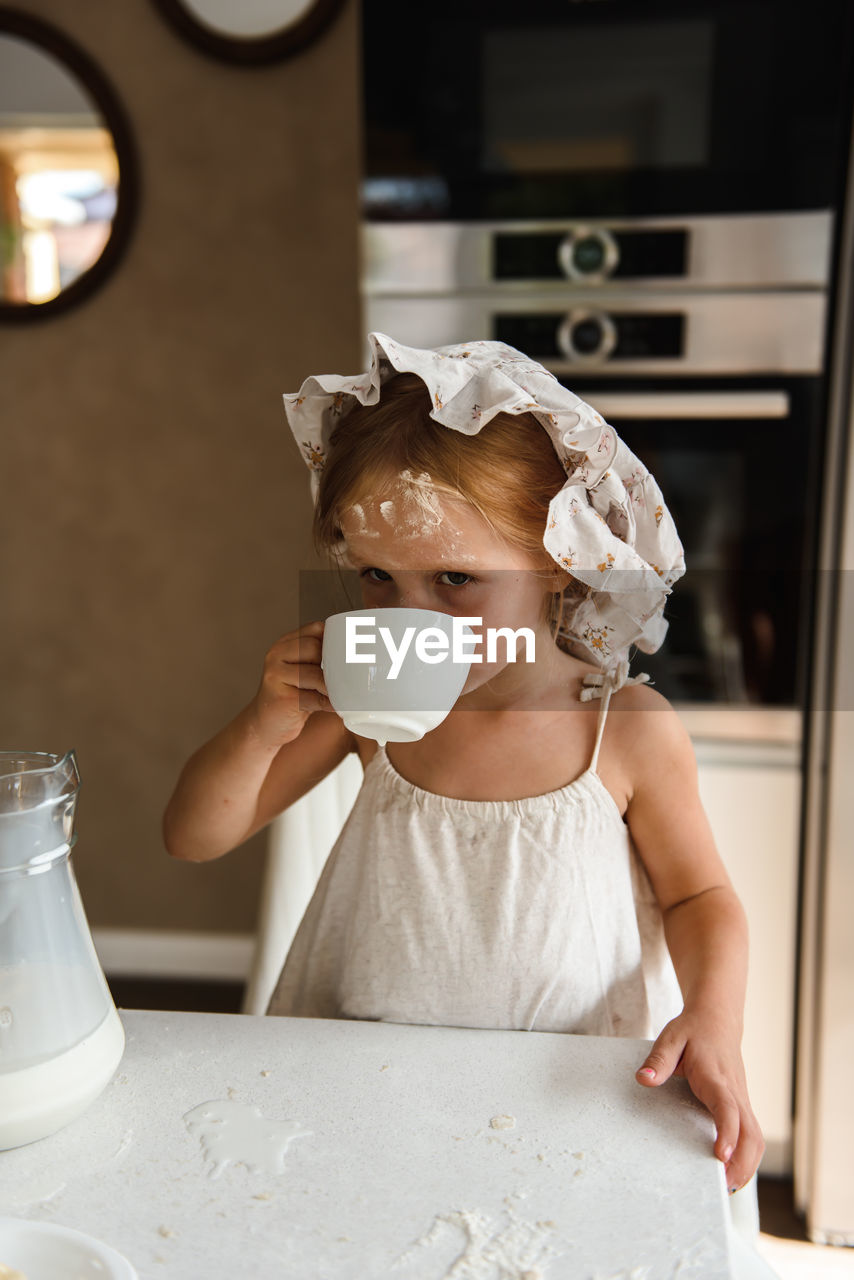 Little girl cooking pizza in the kitchen