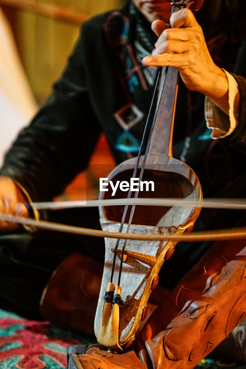 Midsection of man playing violin