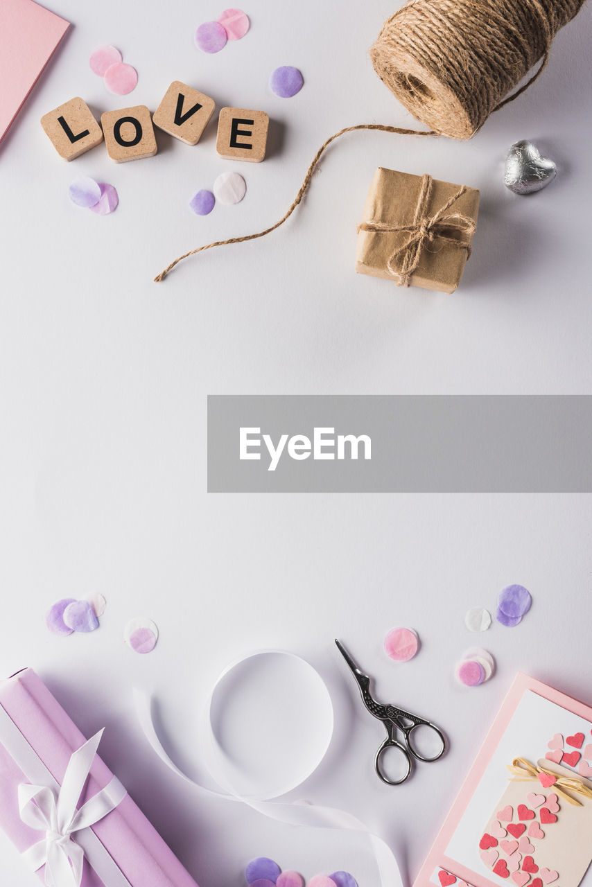 pink, indoors, studio shot, no people, purple, scissors, text, still life, creativity, font, lavender, large group of objects, heart shape, high angle view, paper