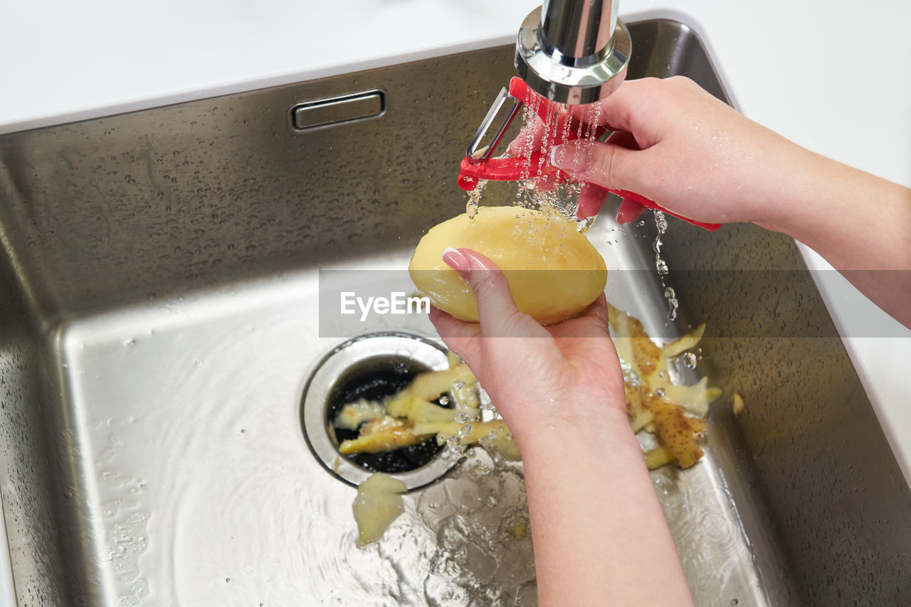 MIDSECTION OF WOMAN HOLDING FOOD AT HOME