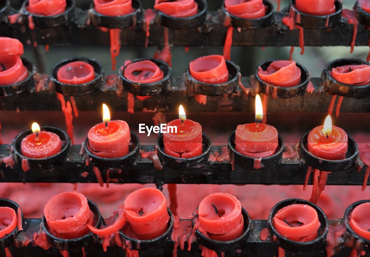 High angle view of illuminated red candles at church