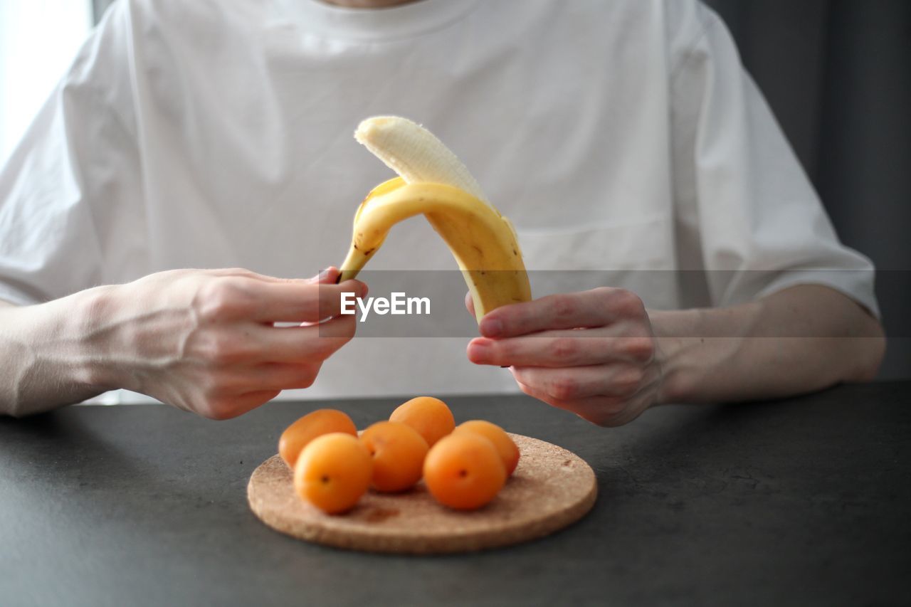 MIDSECTION OF MAN HOLDING FRUITS