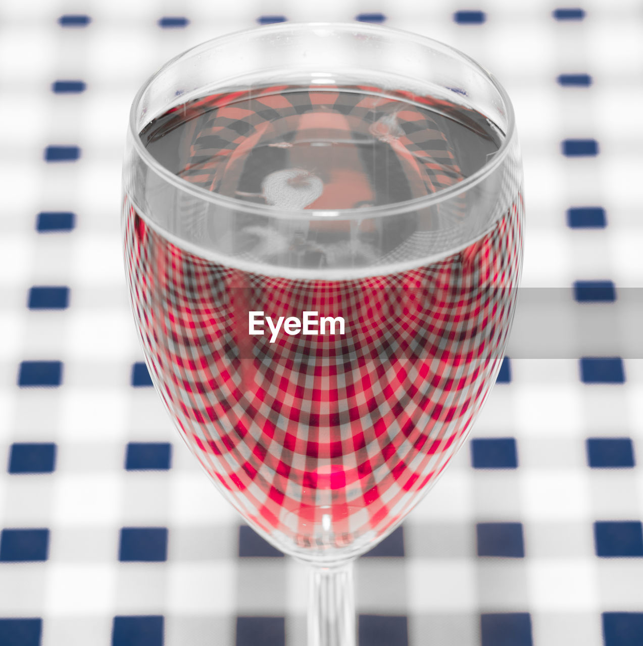 High angle view of wineglass on checked pattern table
