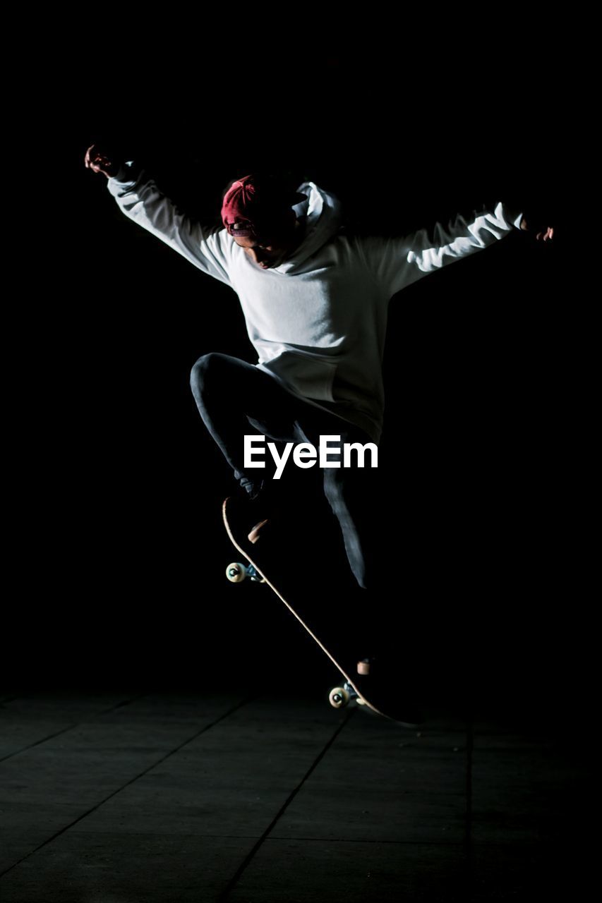 Young man skateboarding at night