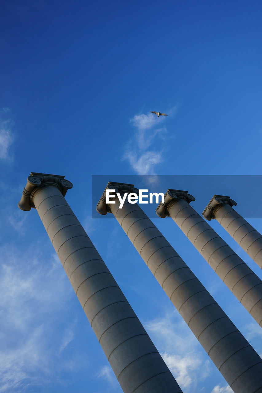 Low angle view of columns against blue sky