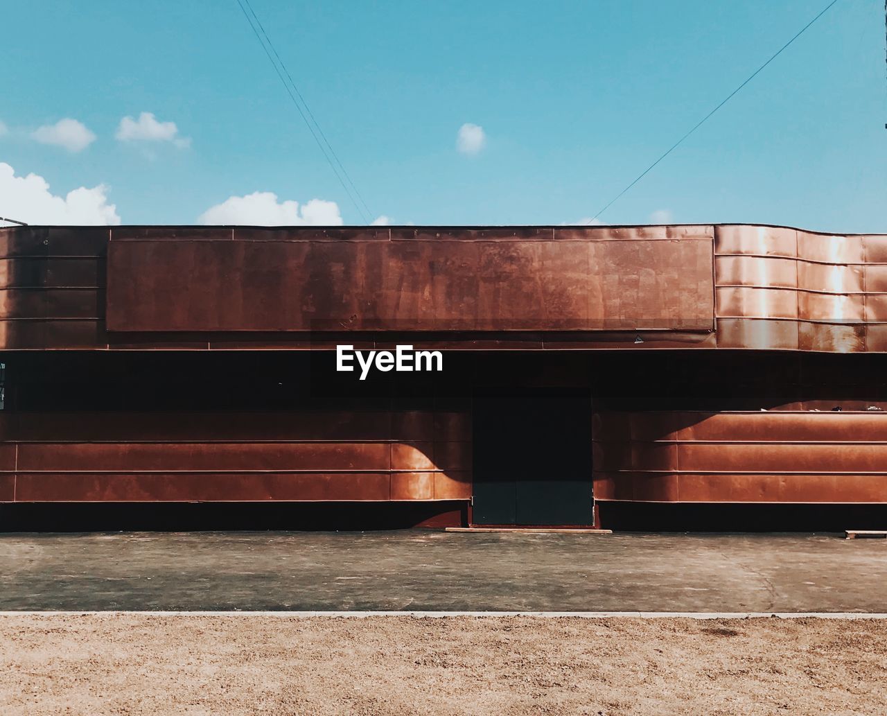 Exterior of brown metal building against sky