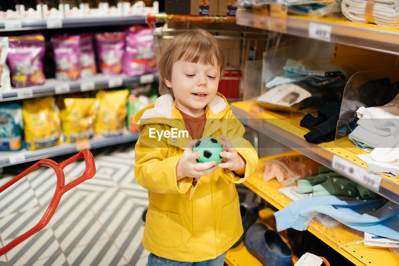 Child in the market buys a small ball