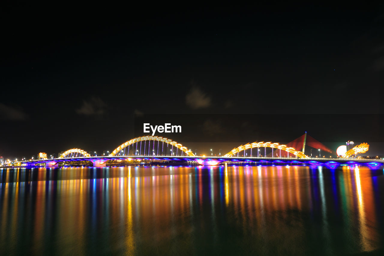 View of illuminated dragon bridge over river