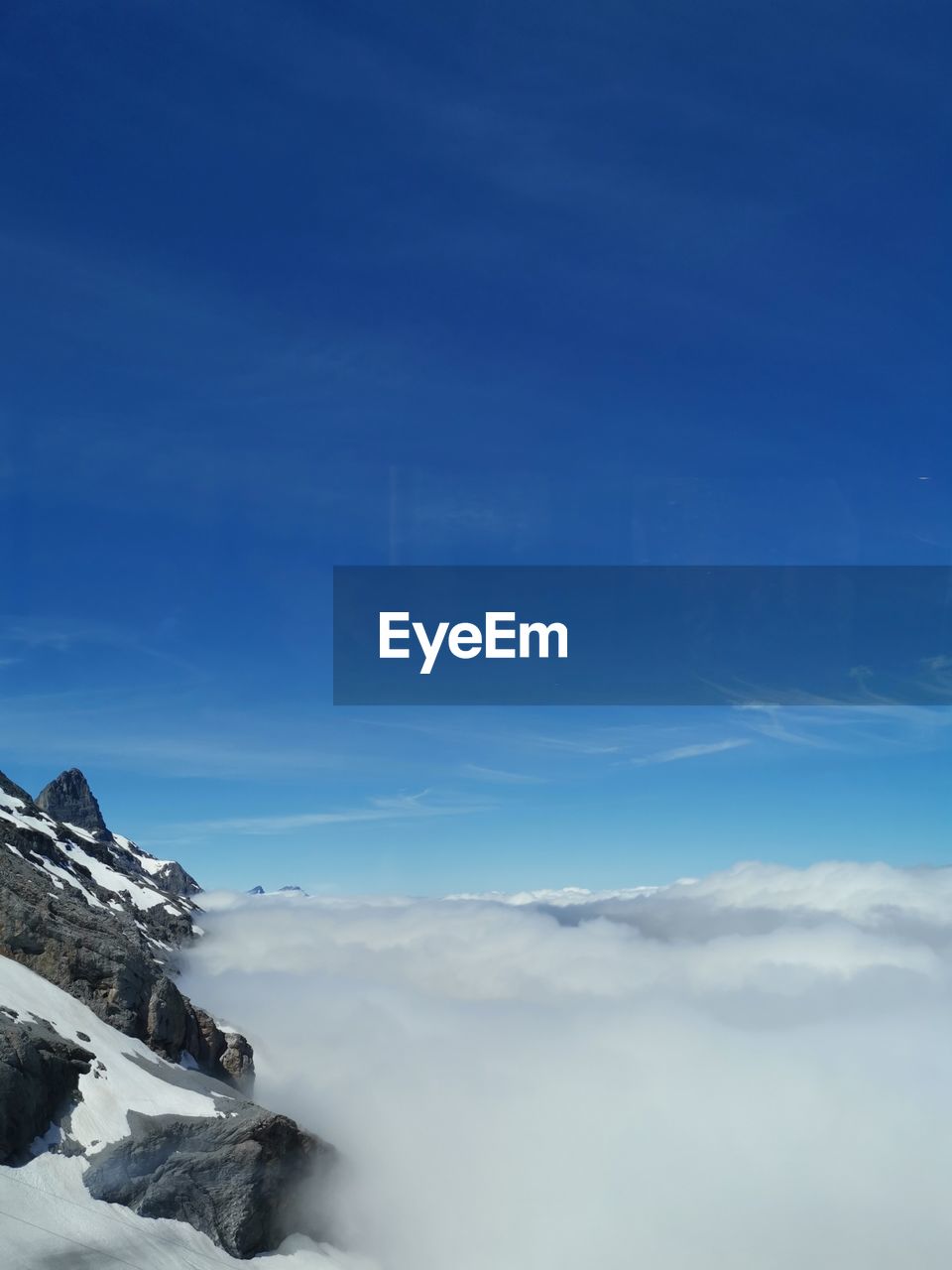 Scenic view of snowcapped mountains against blue sky