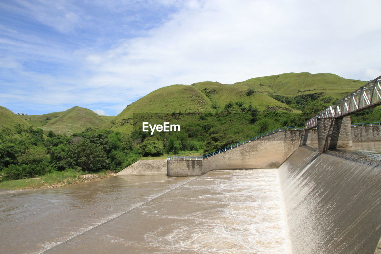 Kambaniru dam combined with hills and green grass and blue sky