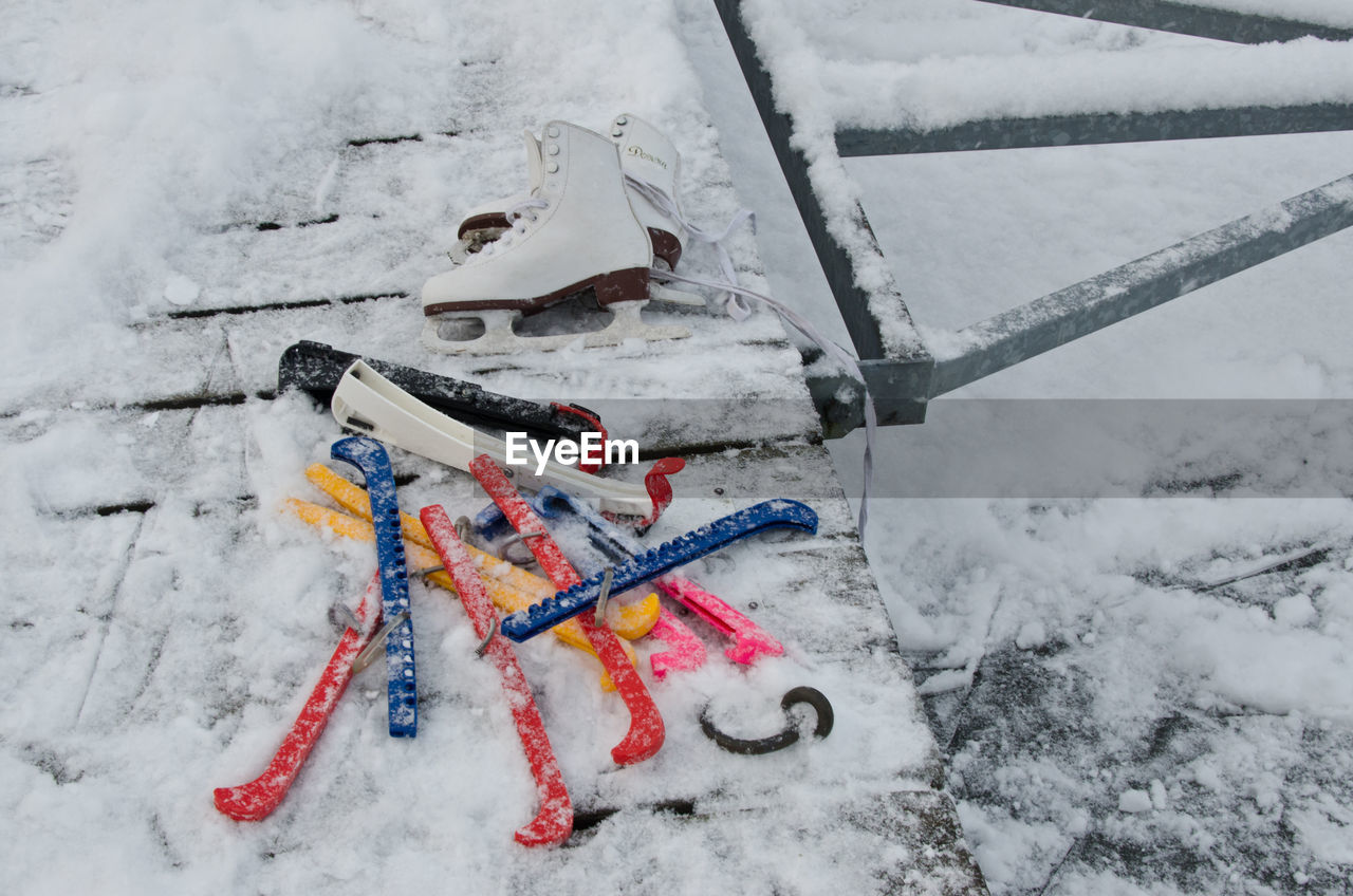 High angle view of ice skates on boardwalk during winter