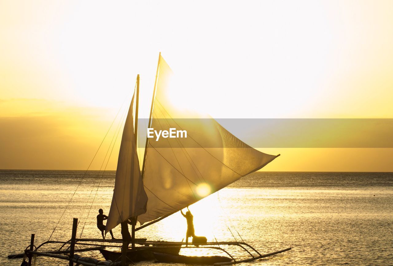 Sailboat on sea against sky during sunset