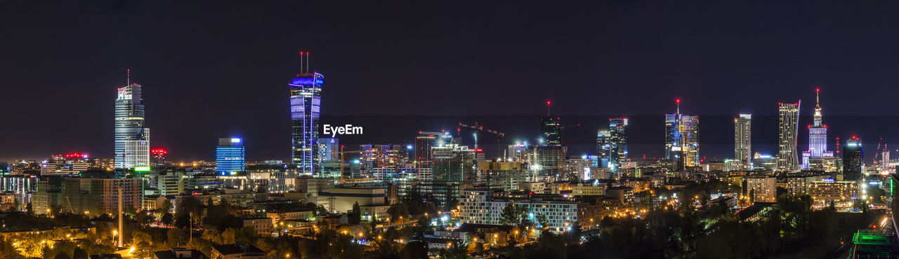 Panoramic view of illuminated buildings against sky at night