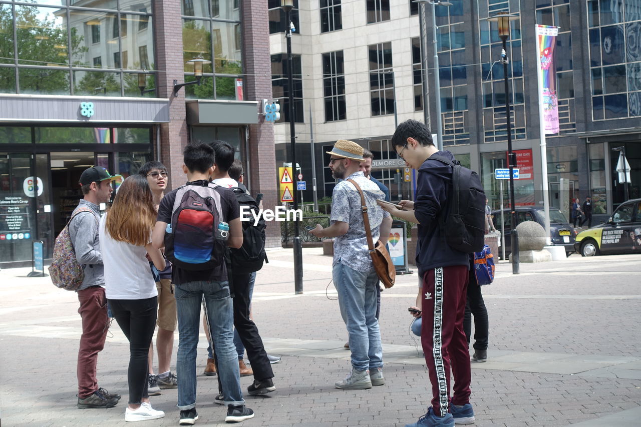 PEOPLE WALKING ON FOOTPATH IN CITY