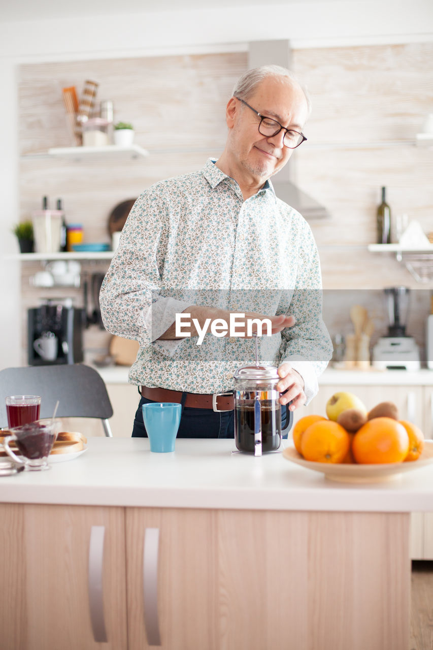 Man preparing coffee while standing at home