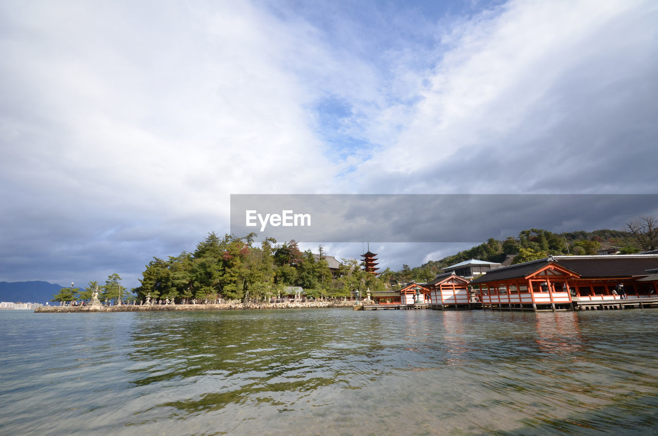 Itsukushima shrine by sea against sky