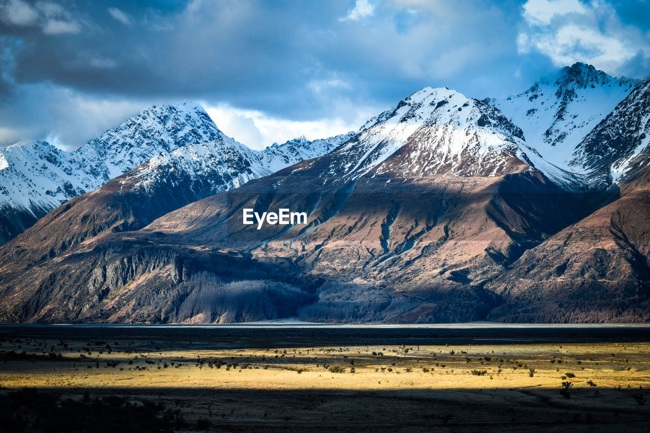 SNOW COVERED MOUNTAINS AGAINST SKY