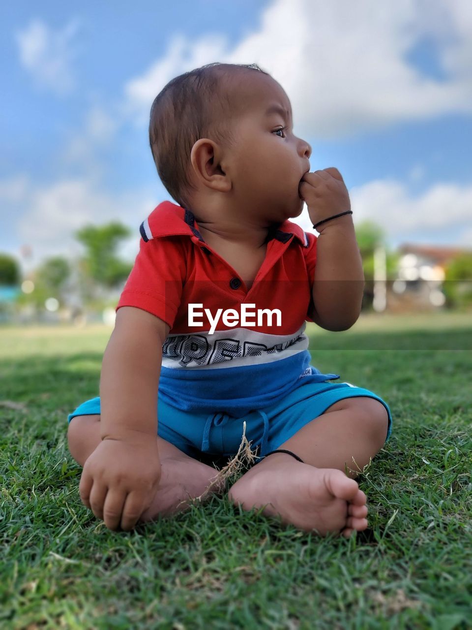 Portrait of cute baby boy standing on field