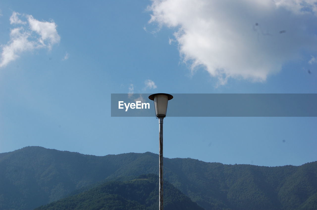 Low angle view of lamp post against mountains