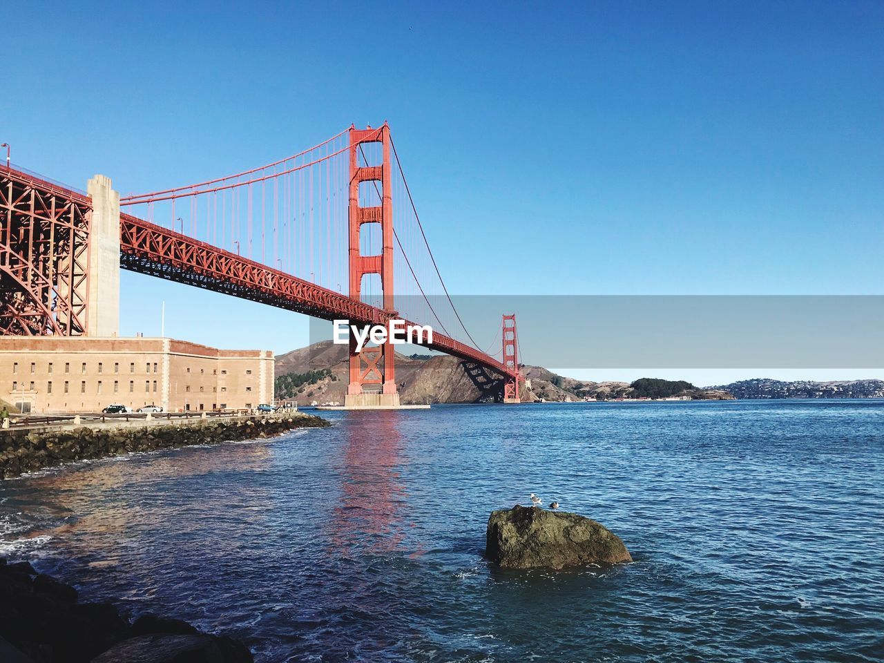 Low angle view of golden gate bridge over bay against clear sky