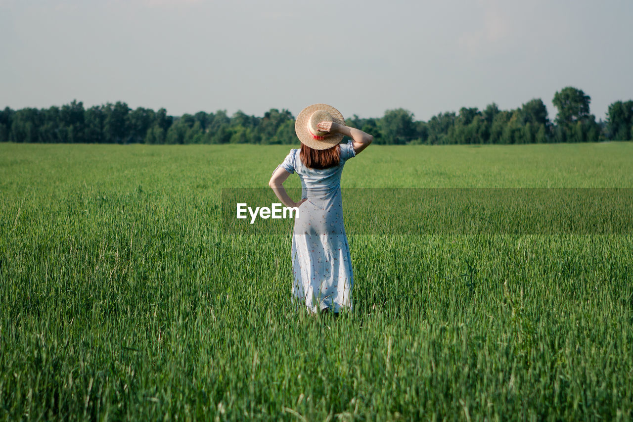 Woman in sunhat in green field