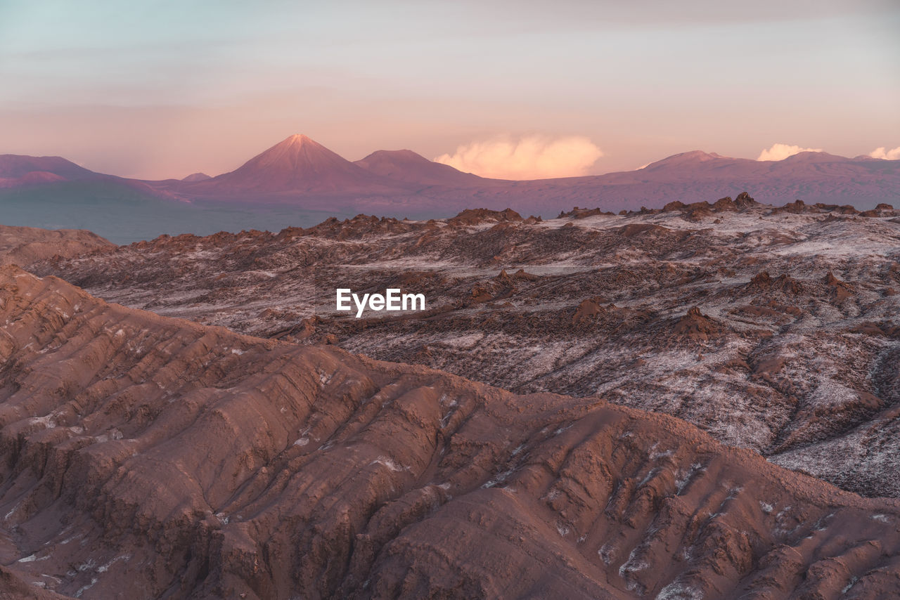 Desert ridgeline in atacama with scenic volcanos in the background
