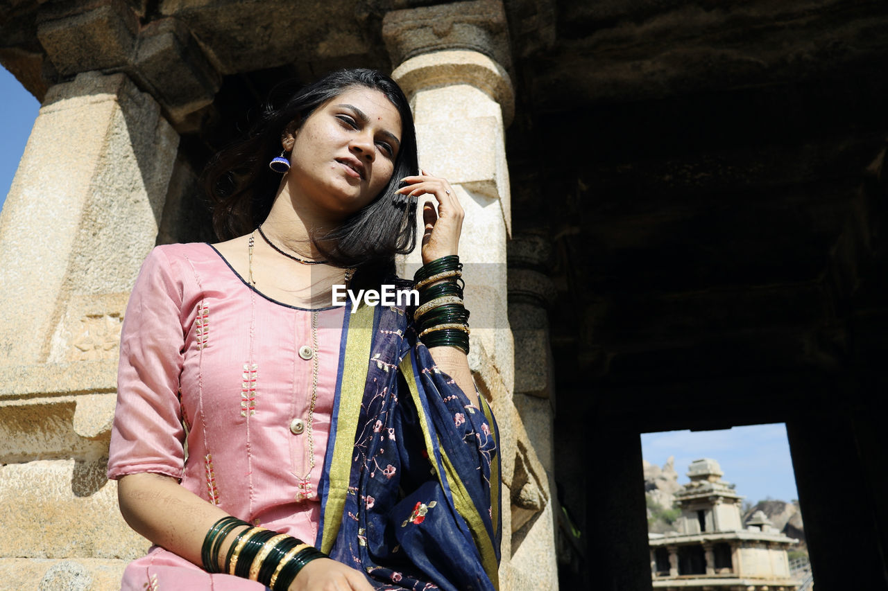 low angle view of woman standing against building