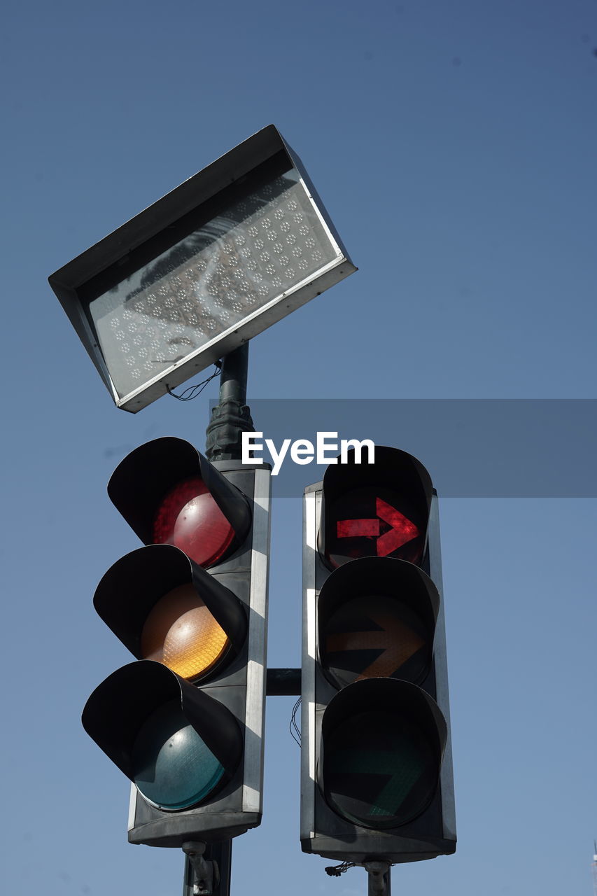 traffic light, signaling device, stoplight, light, sign, road signal, red light, lighting, light fixture, road sign, sky, guidance, blue, green light, communication, lighting equipment, no people, clear sky, road, nature, illuminated, transportation, symbol, screenshot, control, low angle view, red, traffic, city, outdoors, warning sign