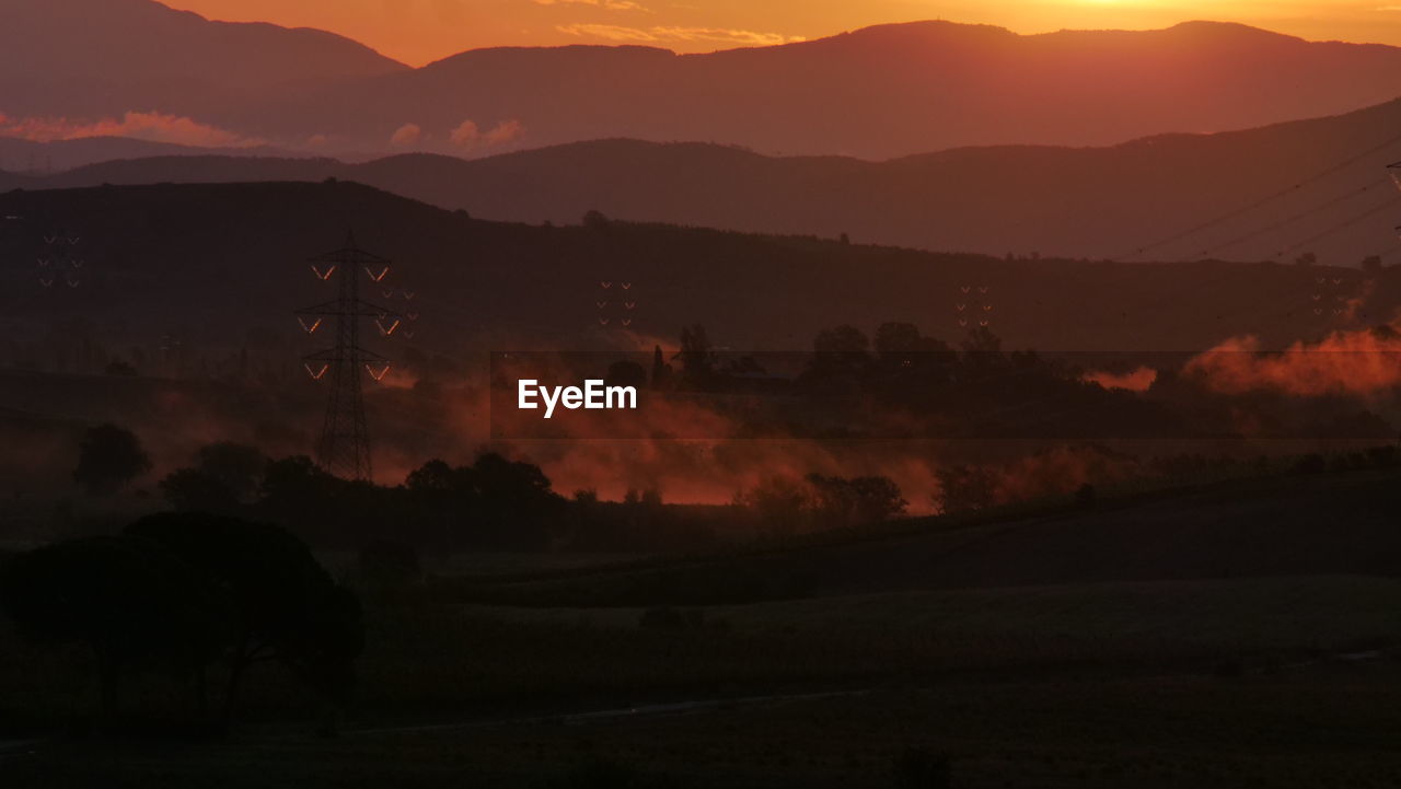 Scenic view of silhouette mountains against sky at sunset