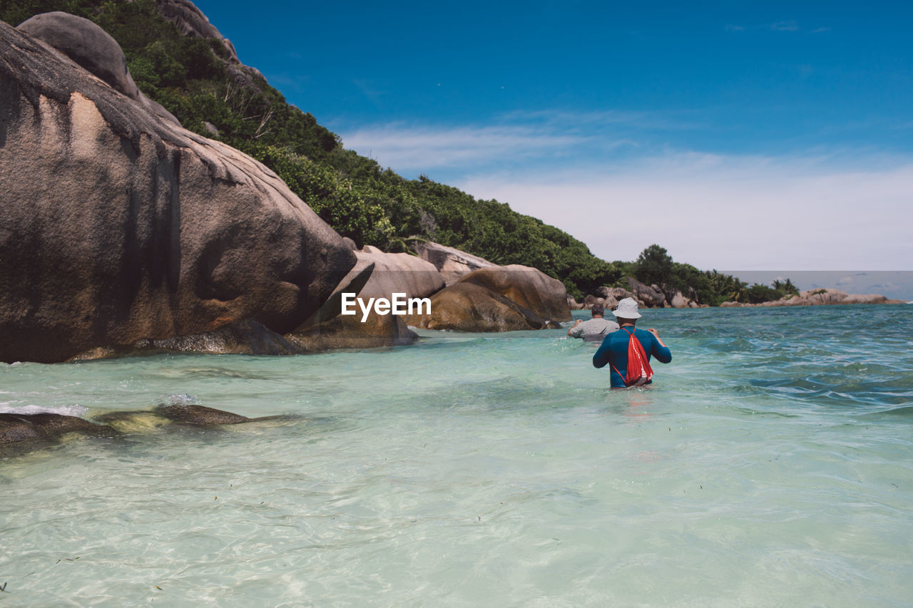 MAN ON ROCK IN SEA