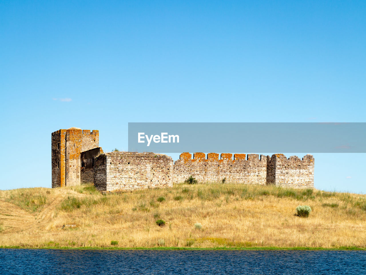 OLD RUINS BY BUILDING AGAINST CLEAR BLUE SKY