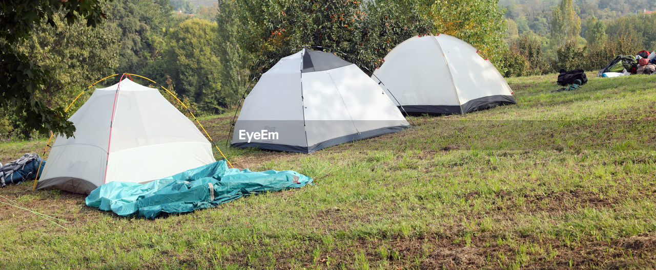 TENT ON FIELD AGAINST TREES AND PLANTS