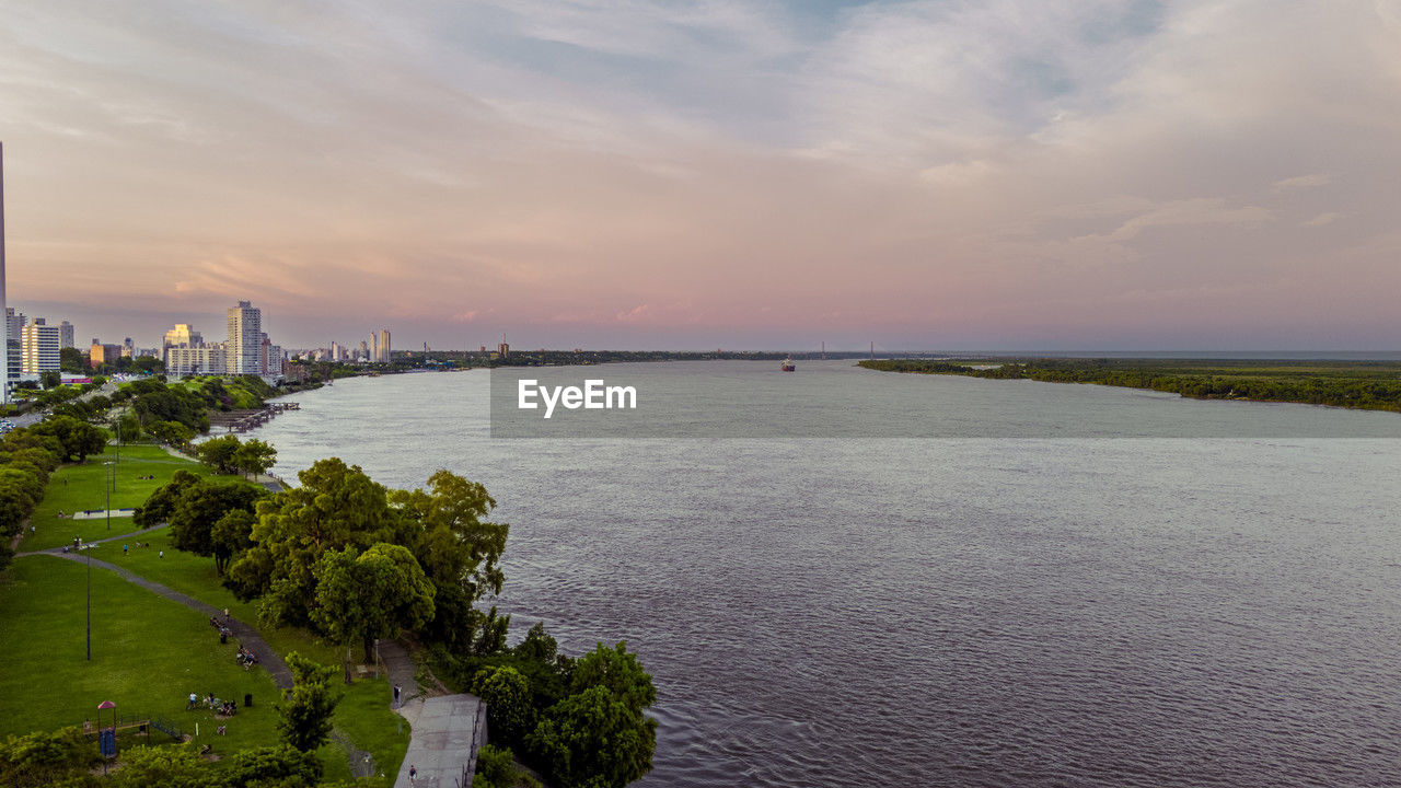 water, sky, architecture, built structure, horizon, coast, city, shore, sea, building exterior, cloud, landscape, travel destinations, nature, sunset, building, environment, bay, travel, scenics - nature, land, tourism, urban skyline, beauty in nature, body of water, cityscape, plant, reflection, beach, outdoors, no people, transportation, dusk, ocean, tranquility, office building exterior, skyscraper, tree, trip, vacation, holiday, coastline, business finance and industry, waterway, industry