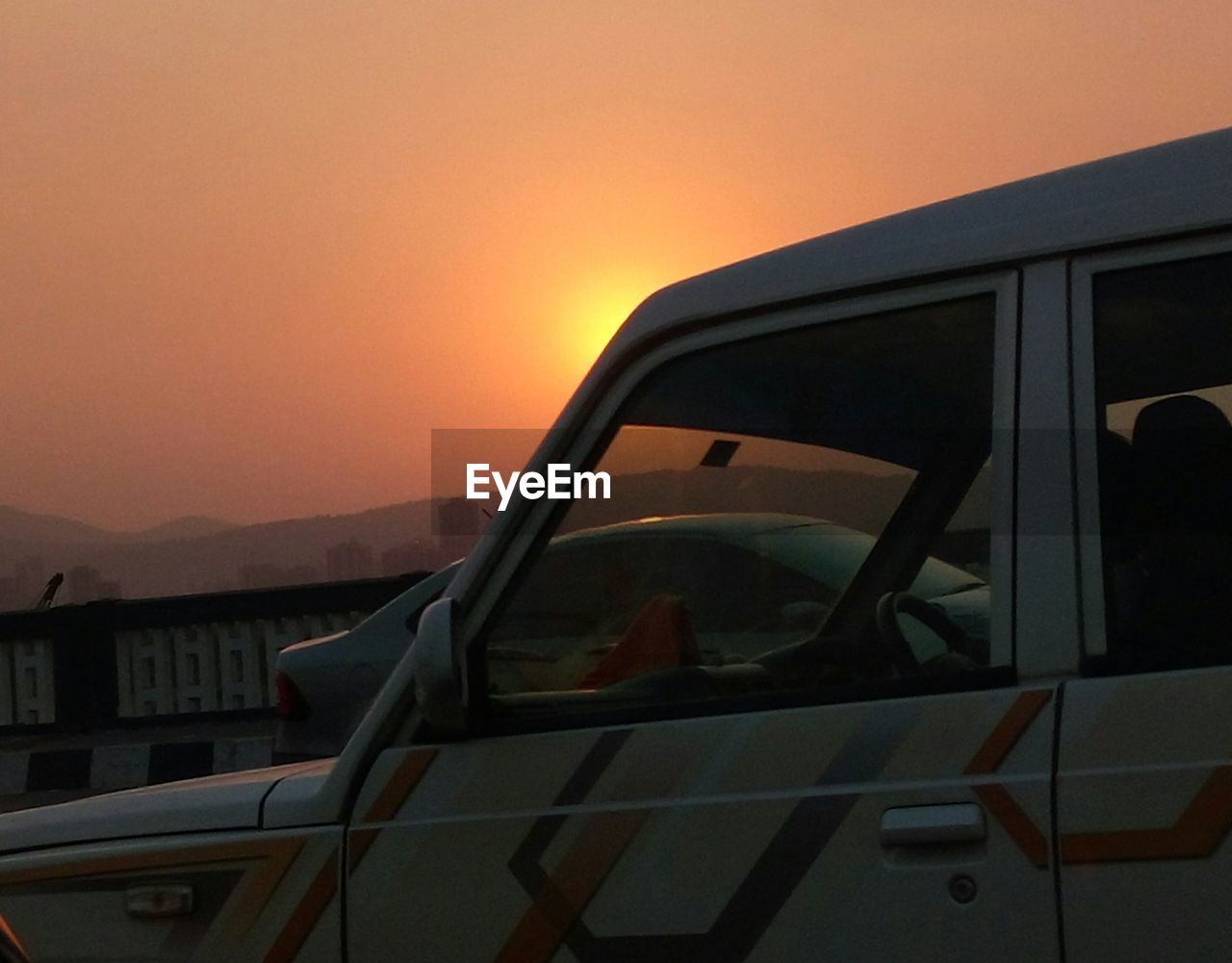 Close-up of car against sky during sunset