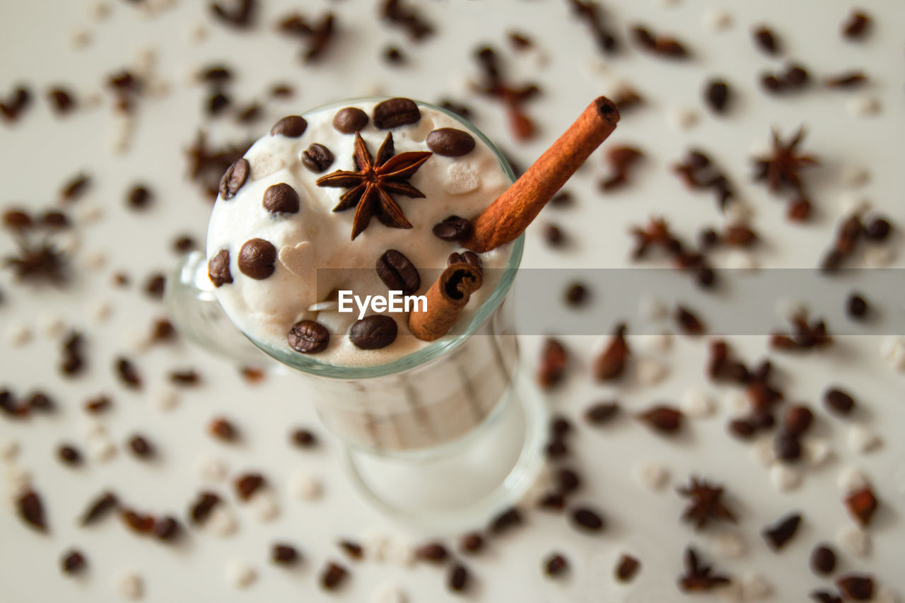 A glass of ice cream with coffee decorated of cinnamon sticks, coffee beans and star of anise. 