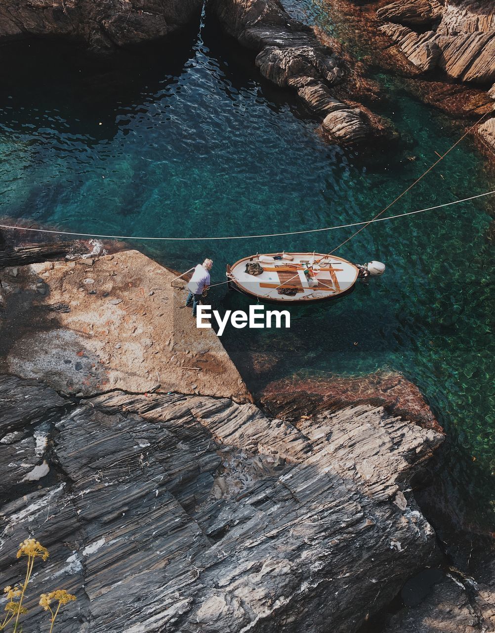 Aerial view of man on rocks by sea