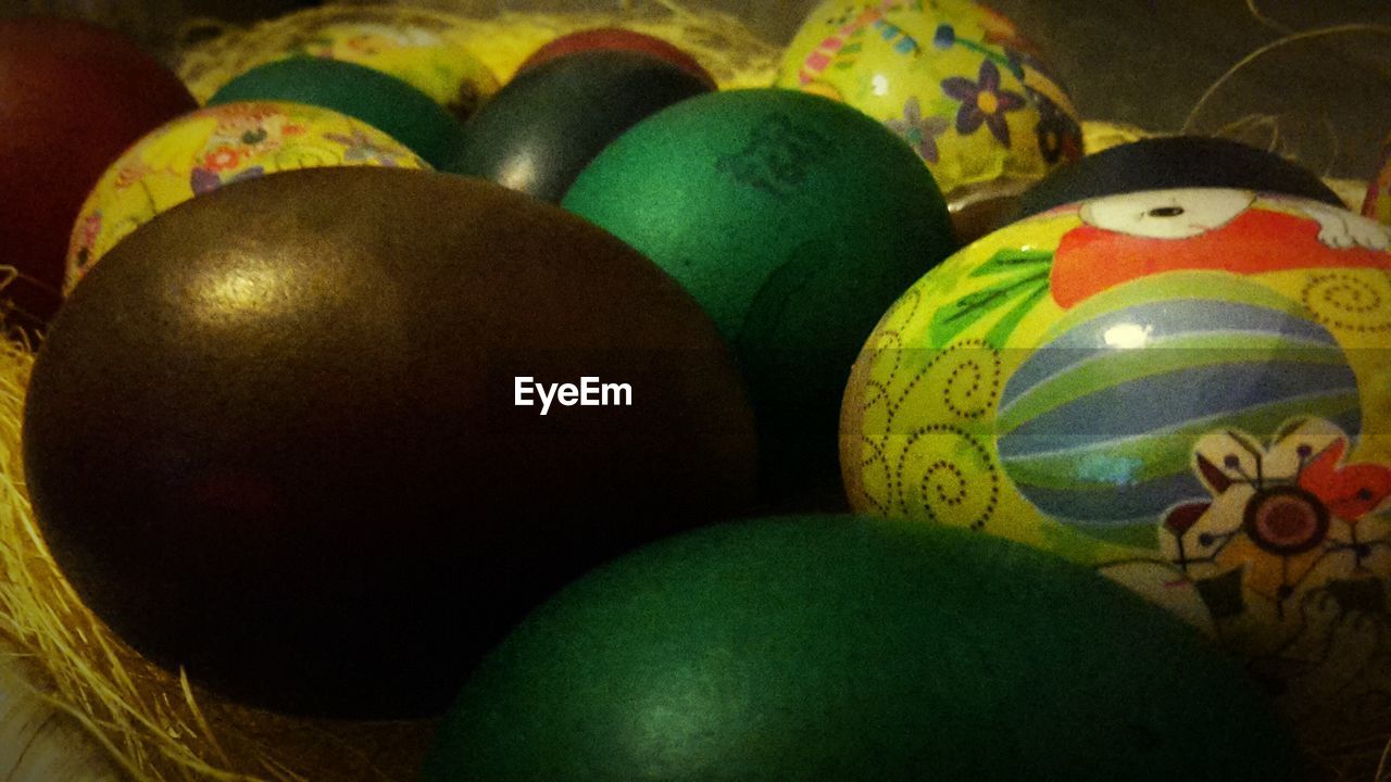 Close-up of multi colored easter eggs in bowl on floor