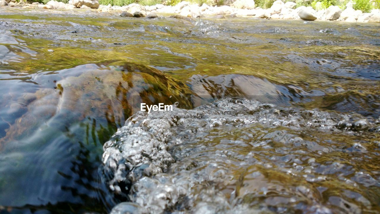 CLOSE UP OF WATER FLOWING IN STREAM