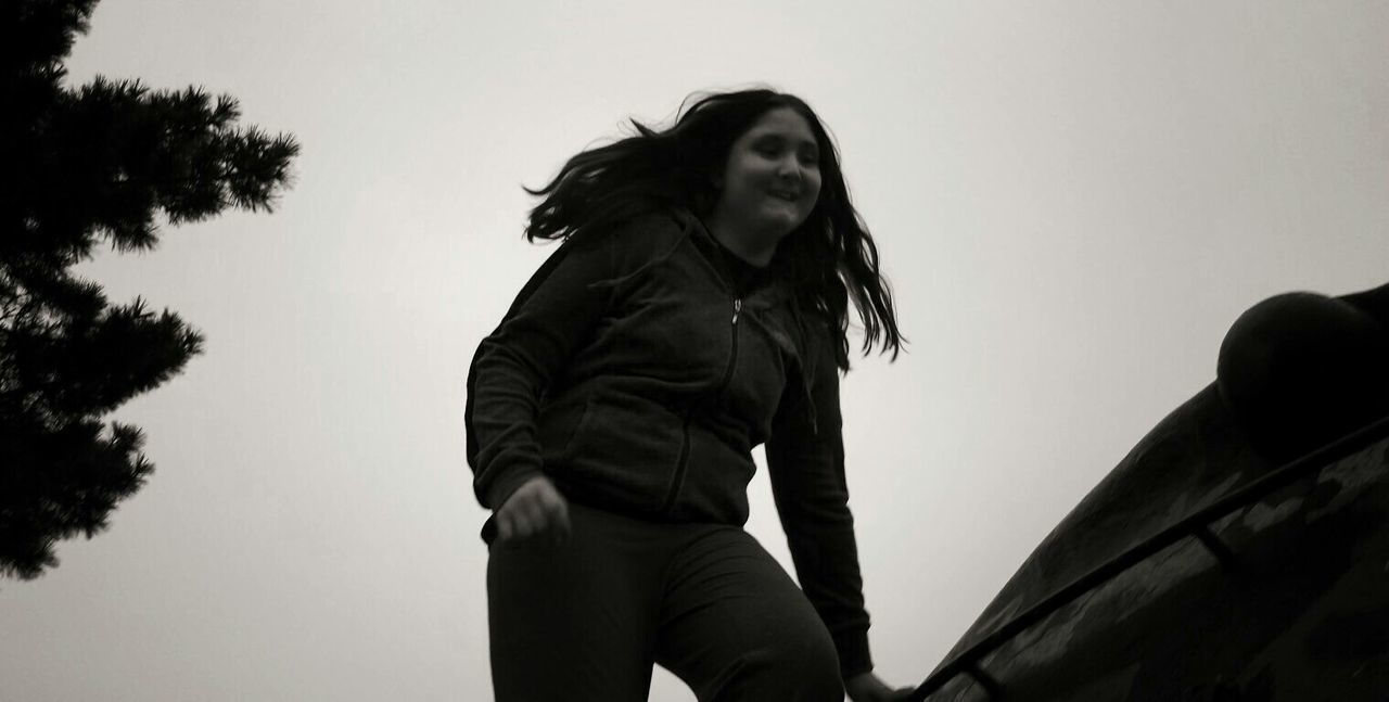 PORTRAIT OF YOUNG WOMAN AGAINST THE SKY