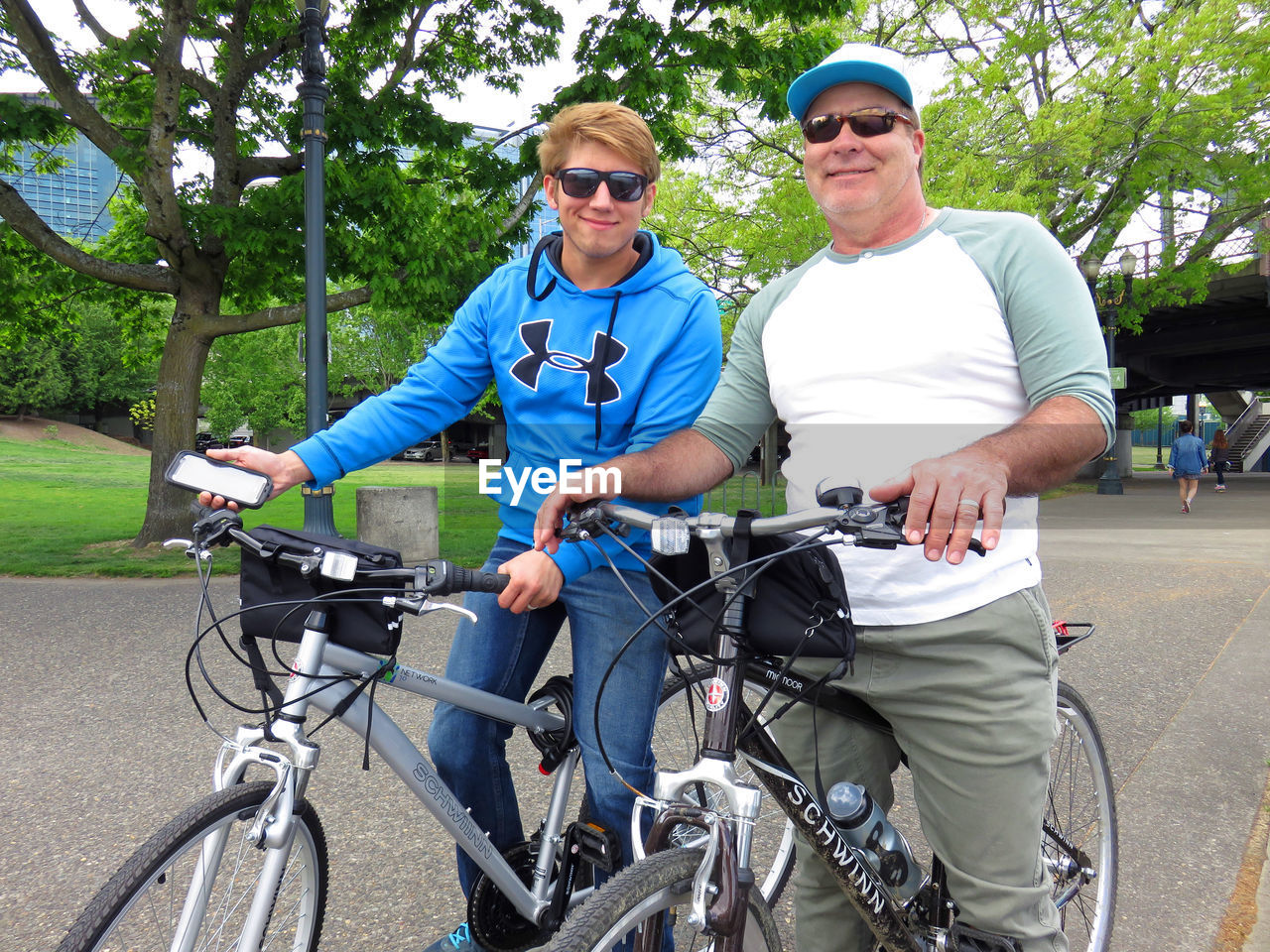 Portrait of father and son on bicycle at street