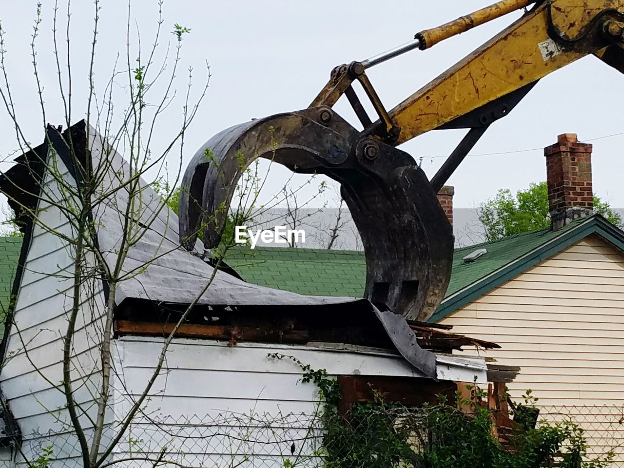 Low angle view of bulldozer demolishing house