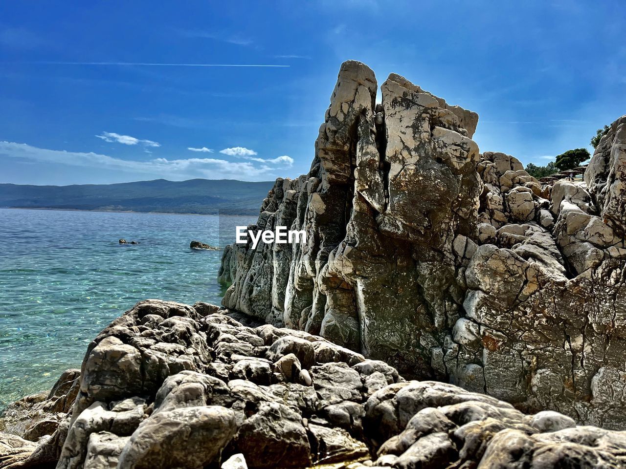 rock, sea, water, sky, coast, nature, scenics - nature, beauty in nature, land, beach, shore, cliff, ocean, cloud, mountain, tranquility, no people, travel destinations, tranquil scene, environment, terrain, geology, travel, rock formation, landscape, outdoors, coastline, day, blue, non-urban scene, formation, bay, vacation, idyllic, sunlight