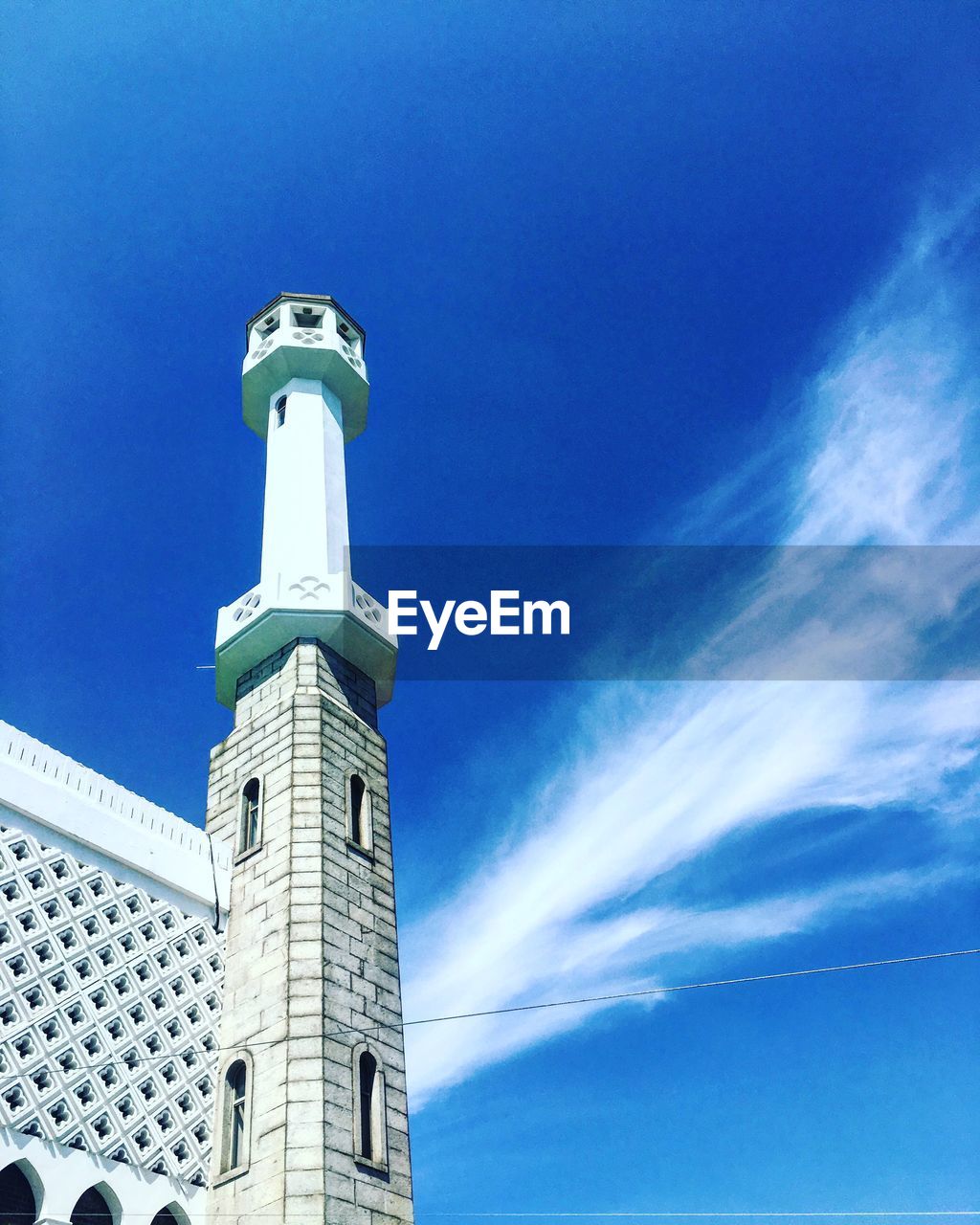 Low angle view of lighthouse against buildings