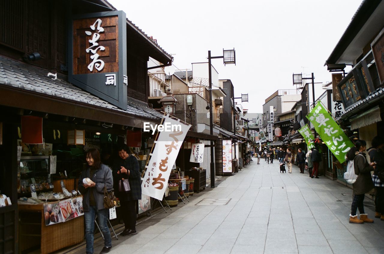 PEOPLE ON STREET AMIDST BUILDINGS