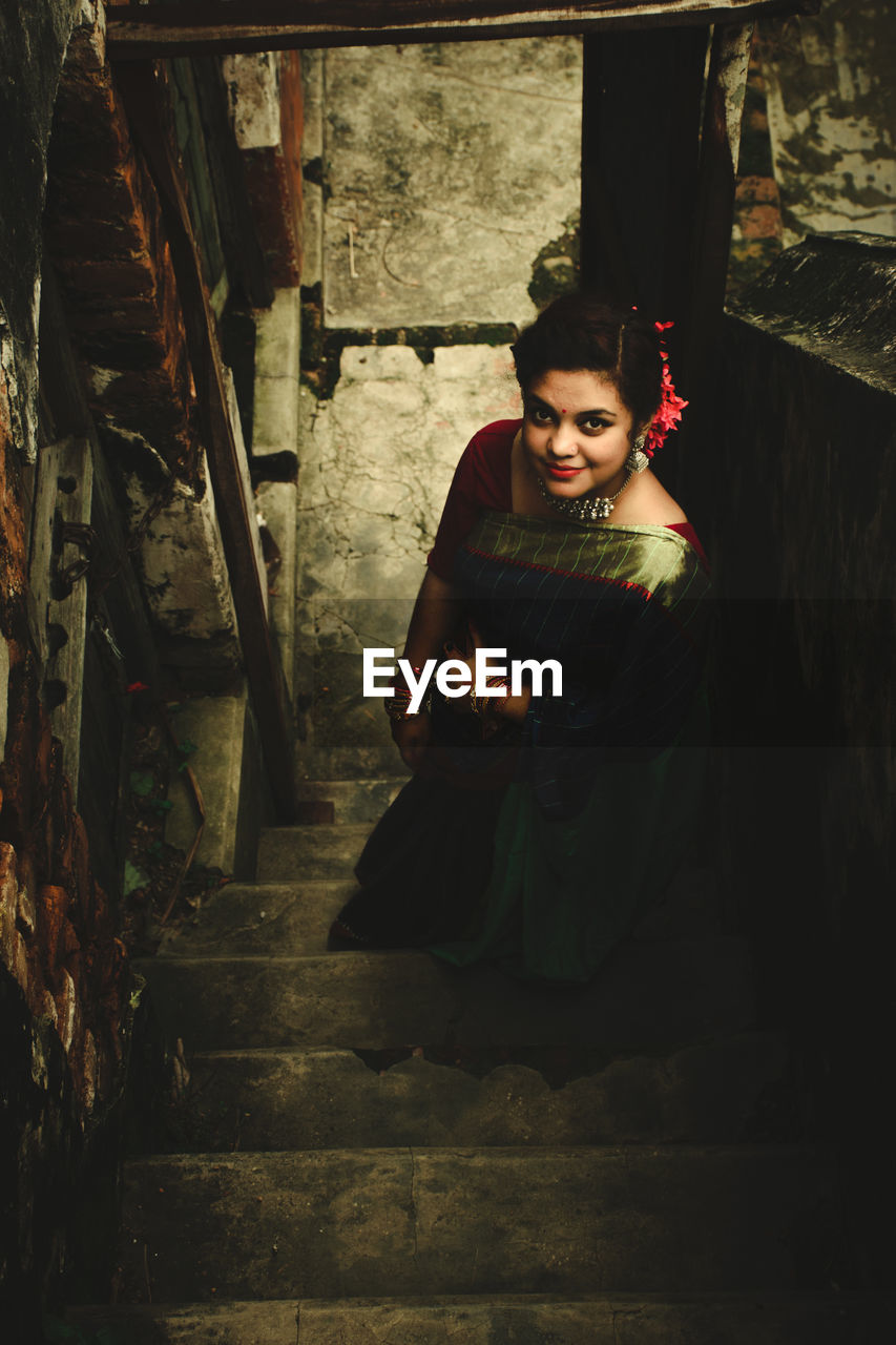 Portrait of young woman sitting on staircase