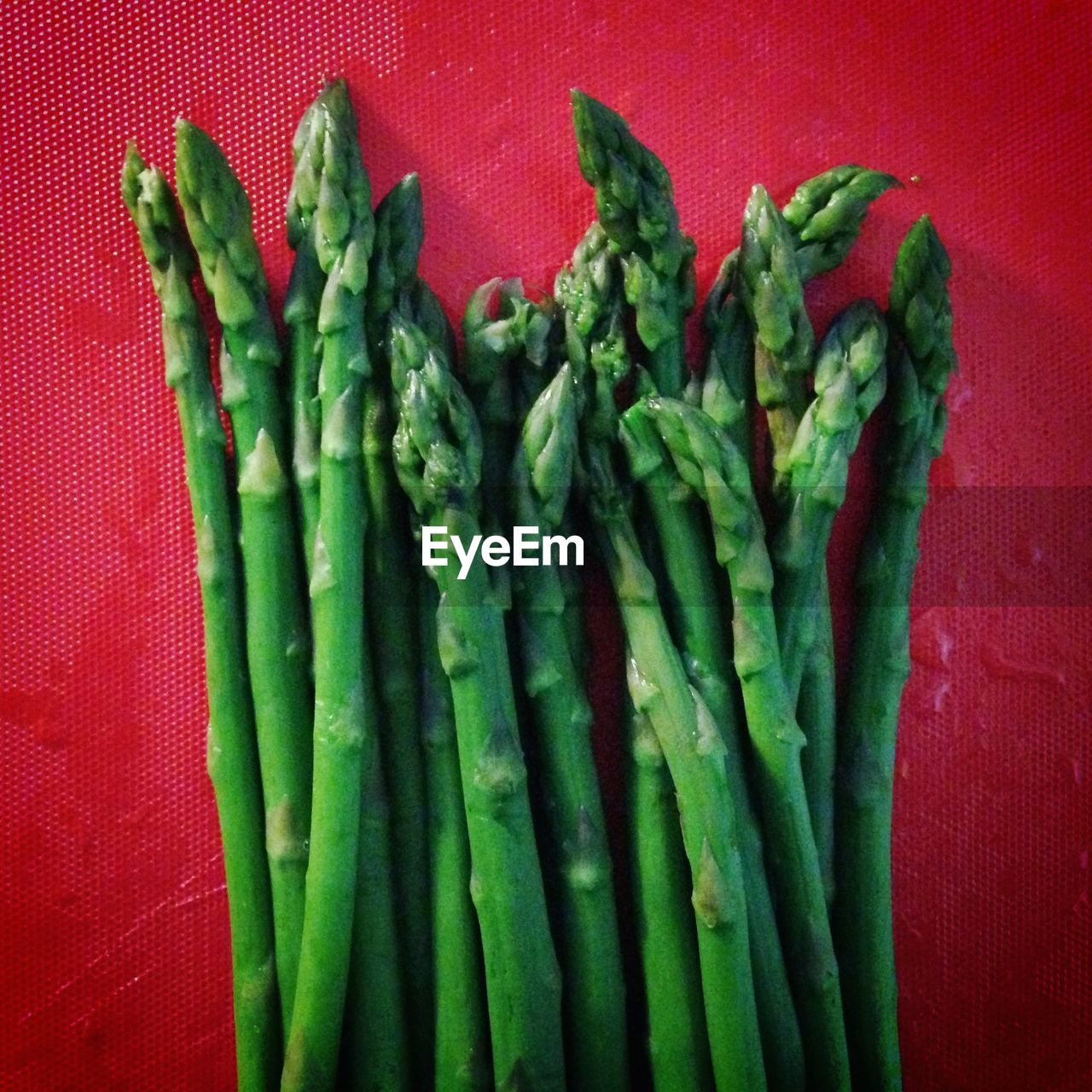 Bunch of asparagus against red background