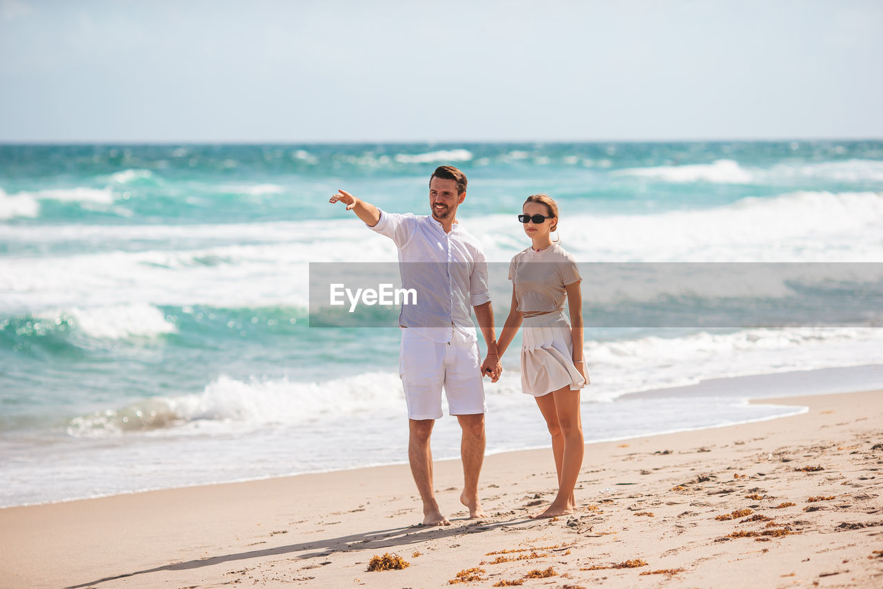 rear view of couple standing at beach