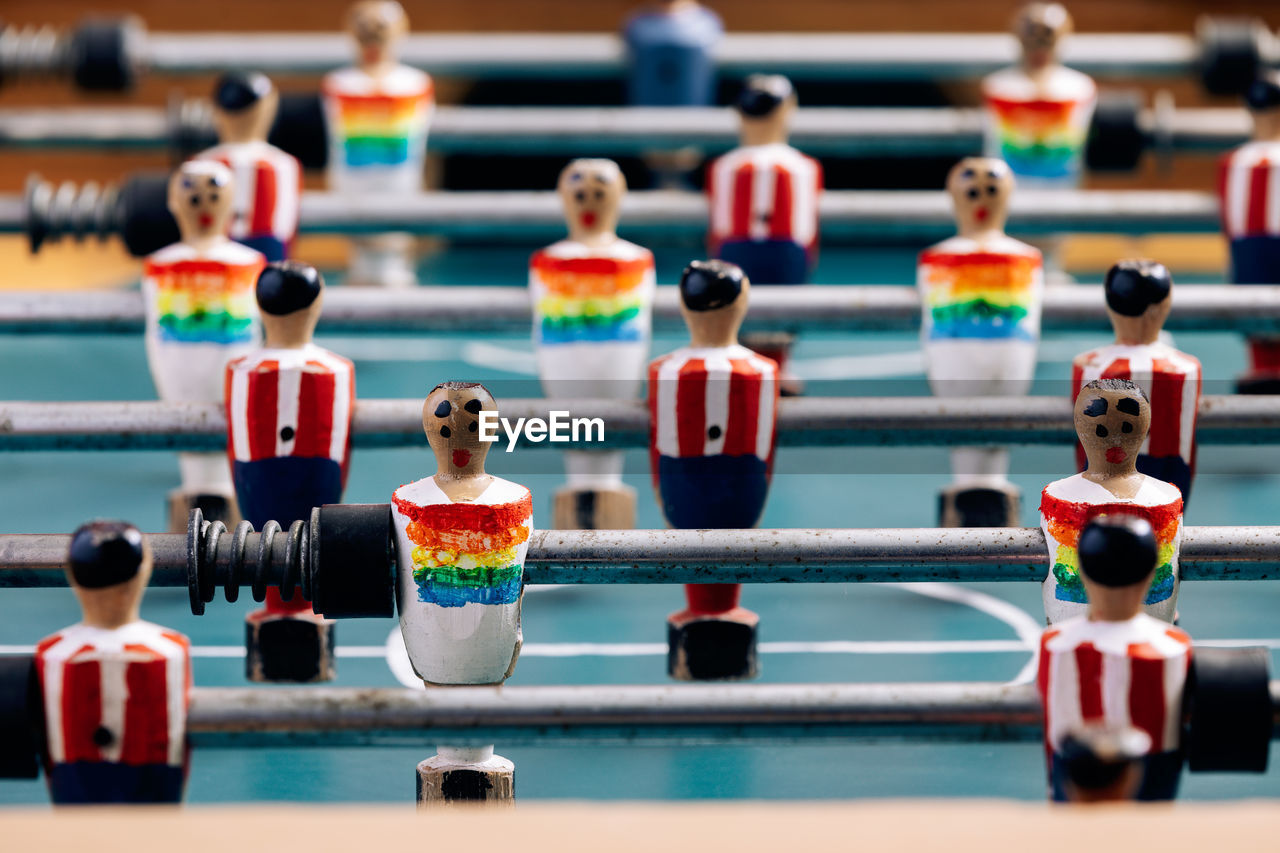 High angle of detail of retro table soccer with wooden miniature figurines of players on metal bars