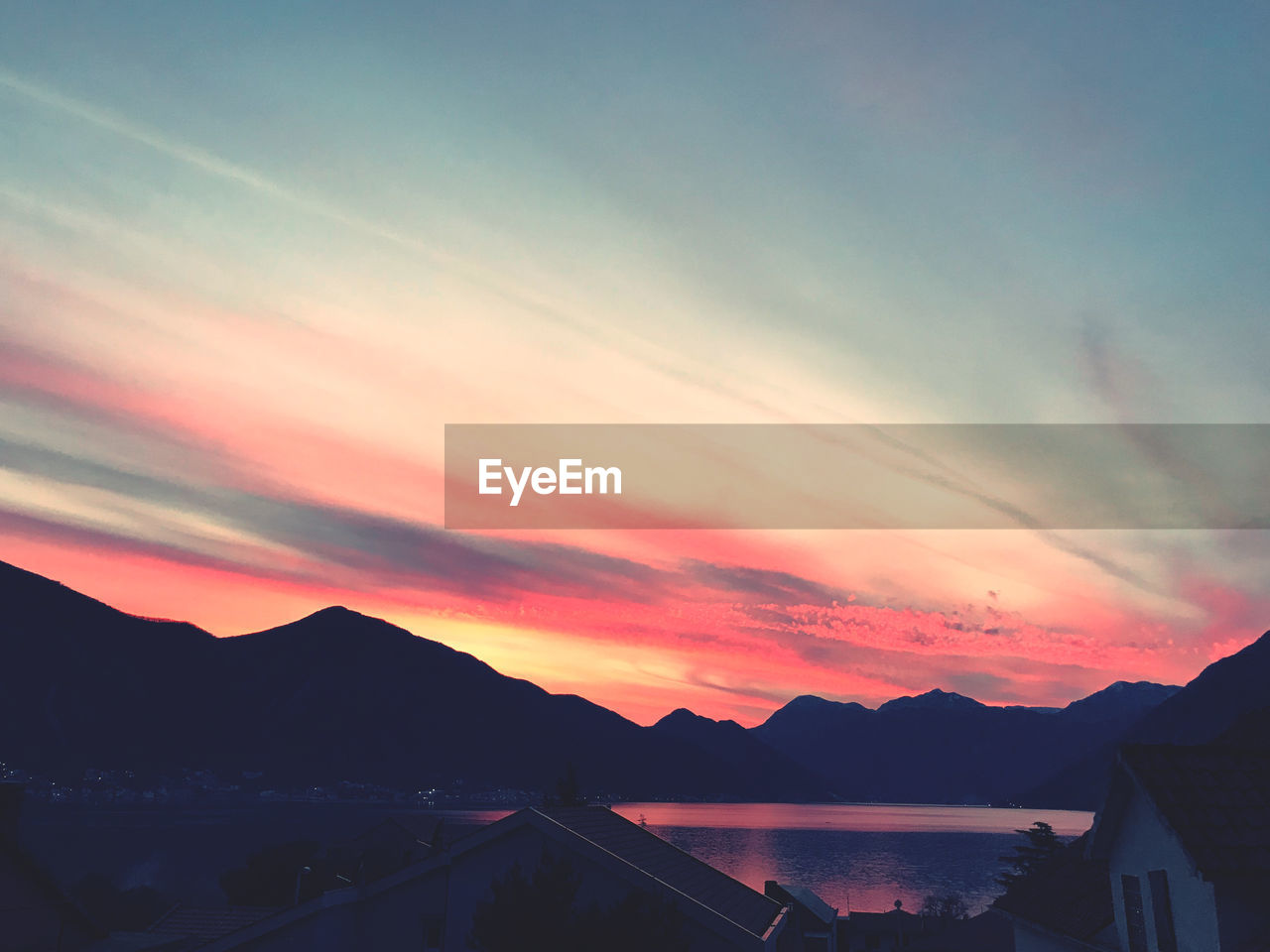 Scenic view of silhouette mountains against romantic sky at sunset