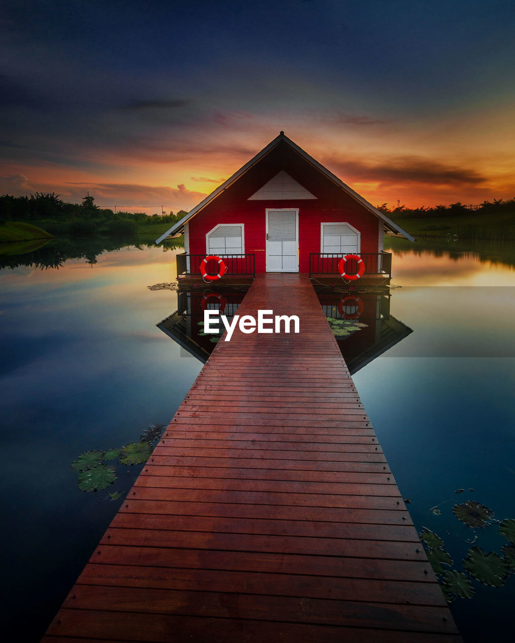 PIER OVER LAKE AGAINST SKY DURING SUNSET